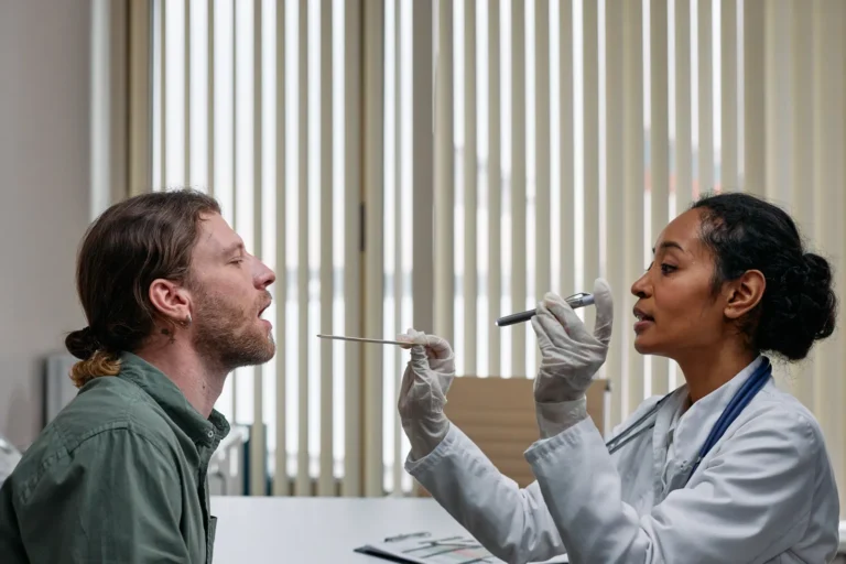 Doctor examining a patient's throat during an ENT exam in a clinical setting