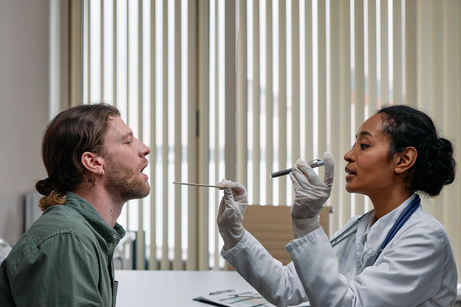 Doctor examining a patient's throat during an ENT exam in a clinical setting
