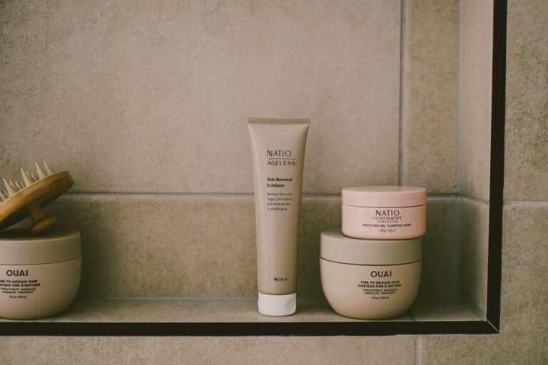 A jar of moisturizer on a bathroom shelf next to a folded towel