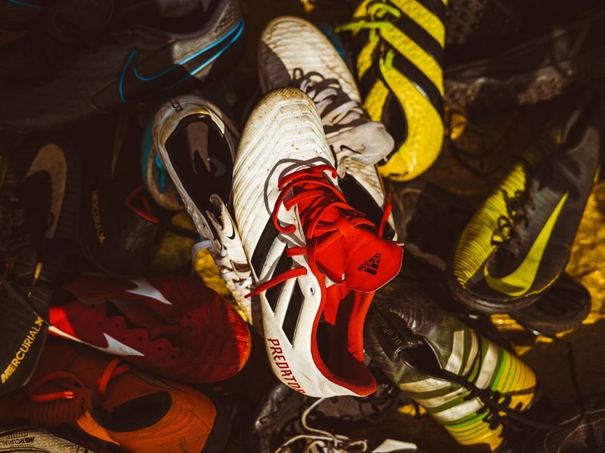 Several pairs of different athletic shoes — running, lifting, and court shoes — lined up side by side