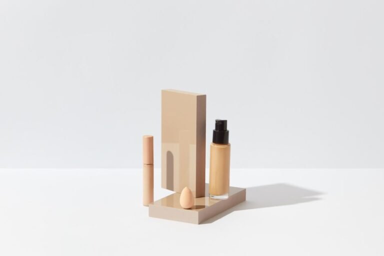 A row of foundation bottles in a range of shades from light to deep on a white surface