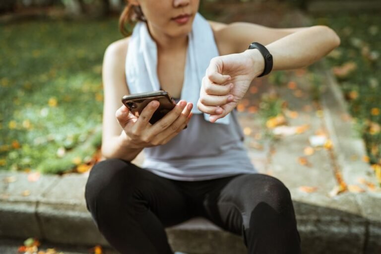 A person sitting calmly and glancing at a fitness watch on their wrist