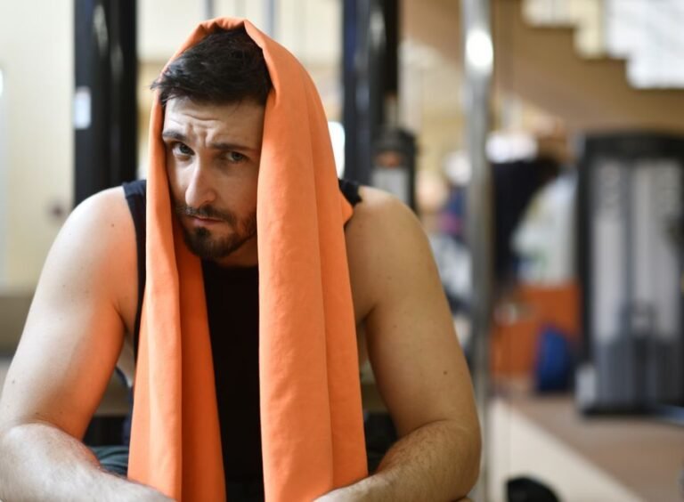 A person doing a light stretch on a gym mat after finishing a workout