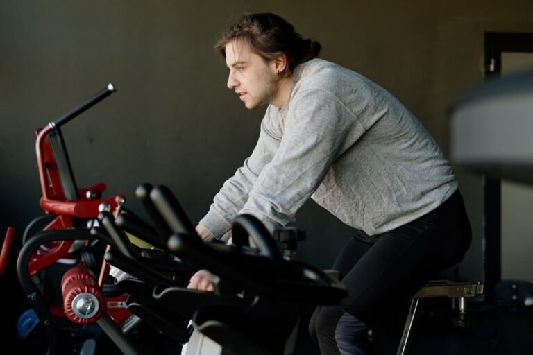 A person in a t-shirt and shorts riding a stationary bike in an ordinary gym
