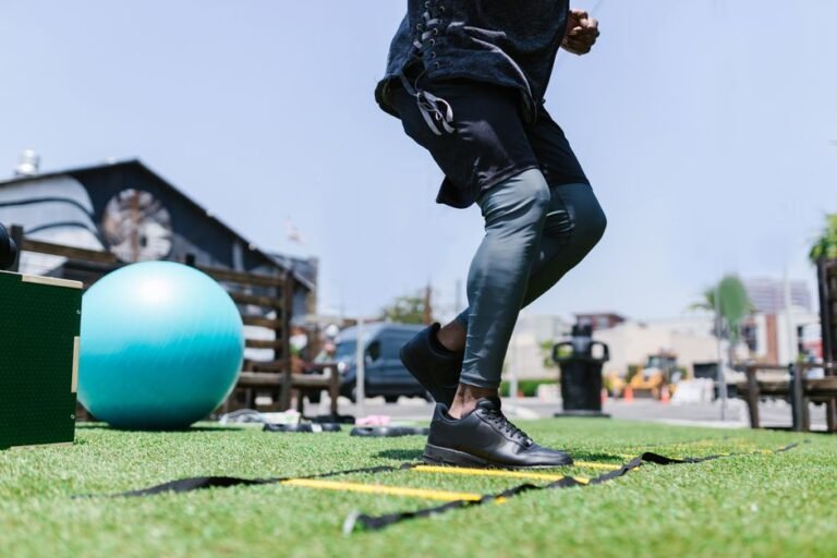 A person performing a kettlebell carry in a gym, holding weights at their sides while walking