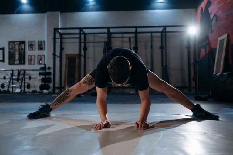A person doing a leg swing stretch on a gym floor before starting a workout