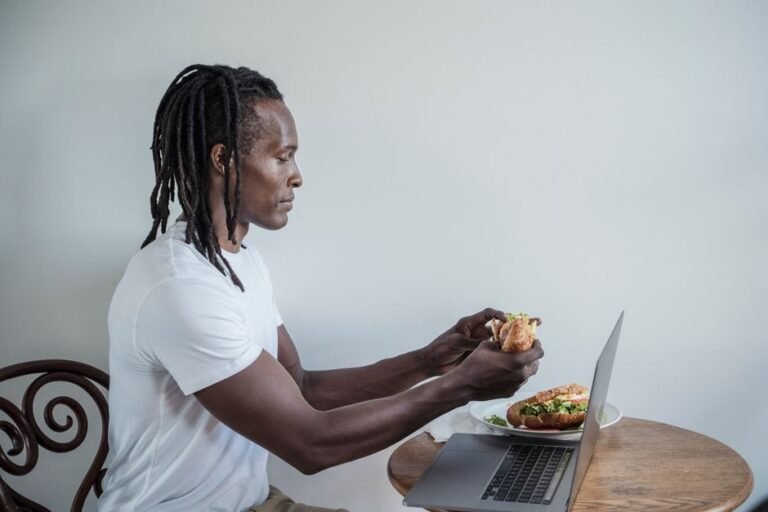 A person eating a light snack at a kitchen table before heading out to exercise