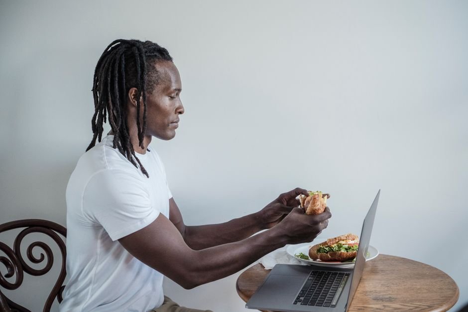 A person eating a light snack at a kitchen table before heading out to exercise