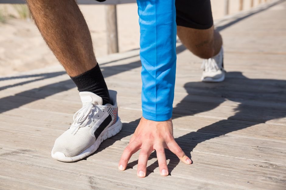 A person beginning a light jog outdoors as part of a workout warm-up