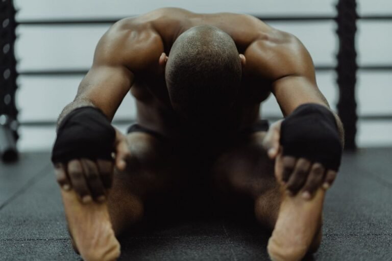 A person stretching their legs on a gym floor after finishing a workout