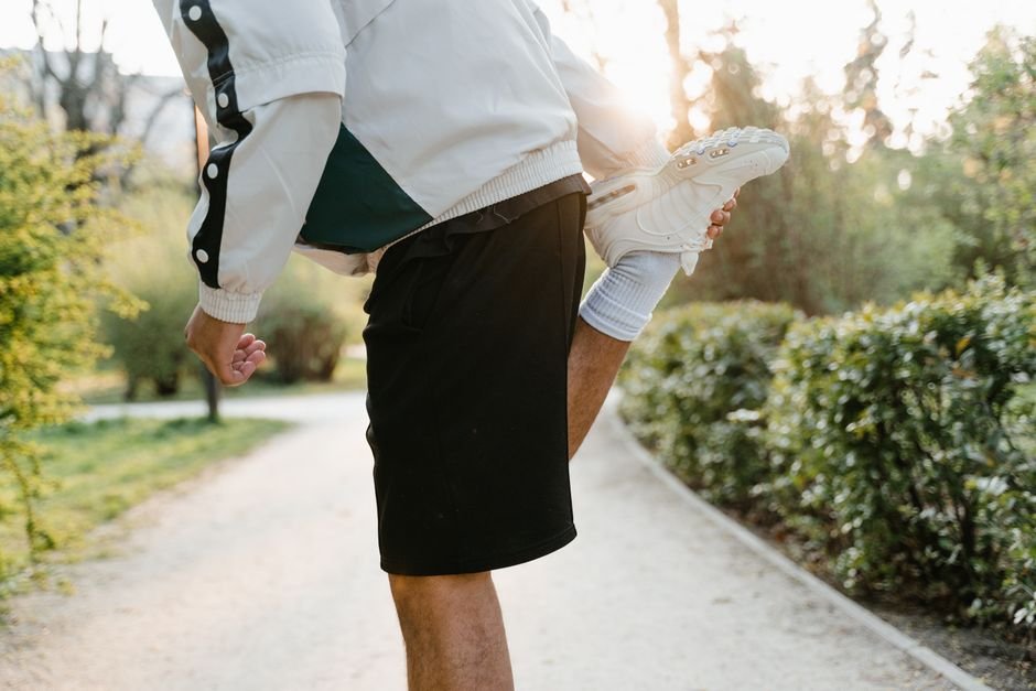 A person stretching their legs on a mat after finishing a workout
