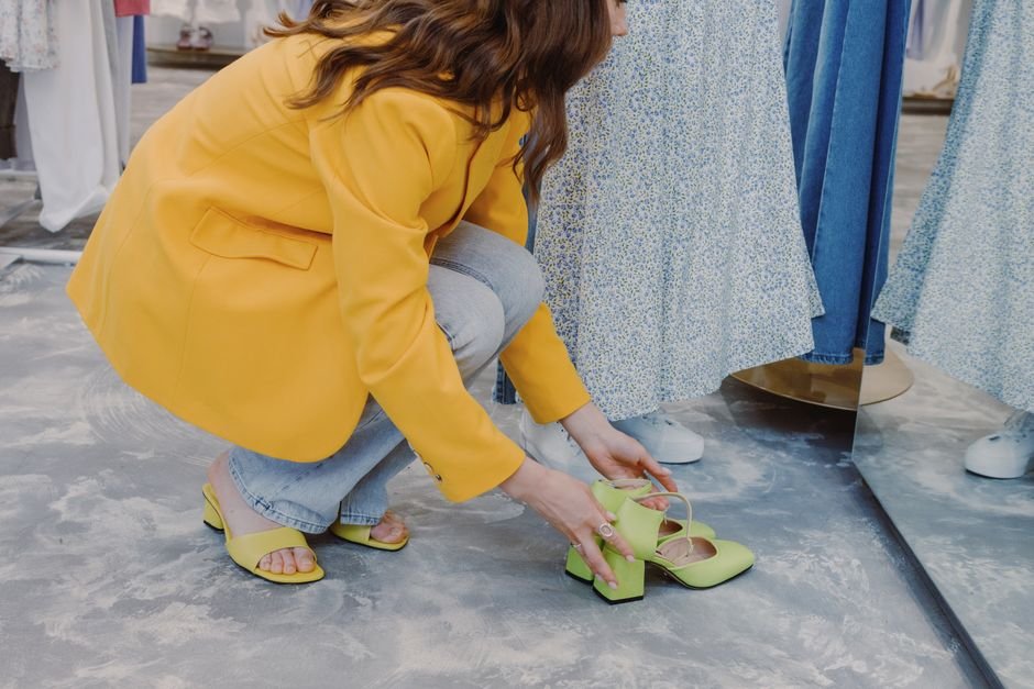 A person trying on a pair of running shoes while seated in a shoe store