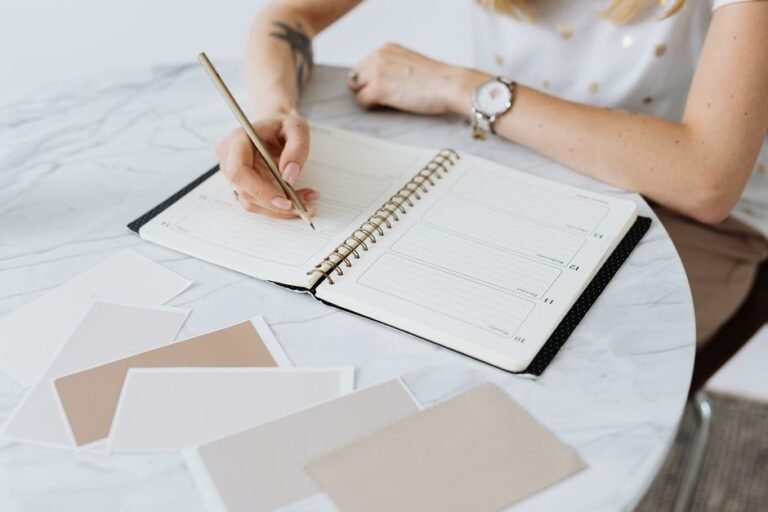 A person writing in a planner next to a water bottle and workout gear