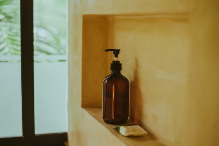 A skincare dropper bottle standing on a bathroom shelf next to other products
