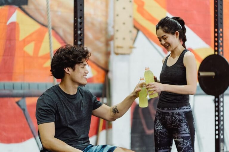 A hand holding a sports drink bottle and reading the ingredient label