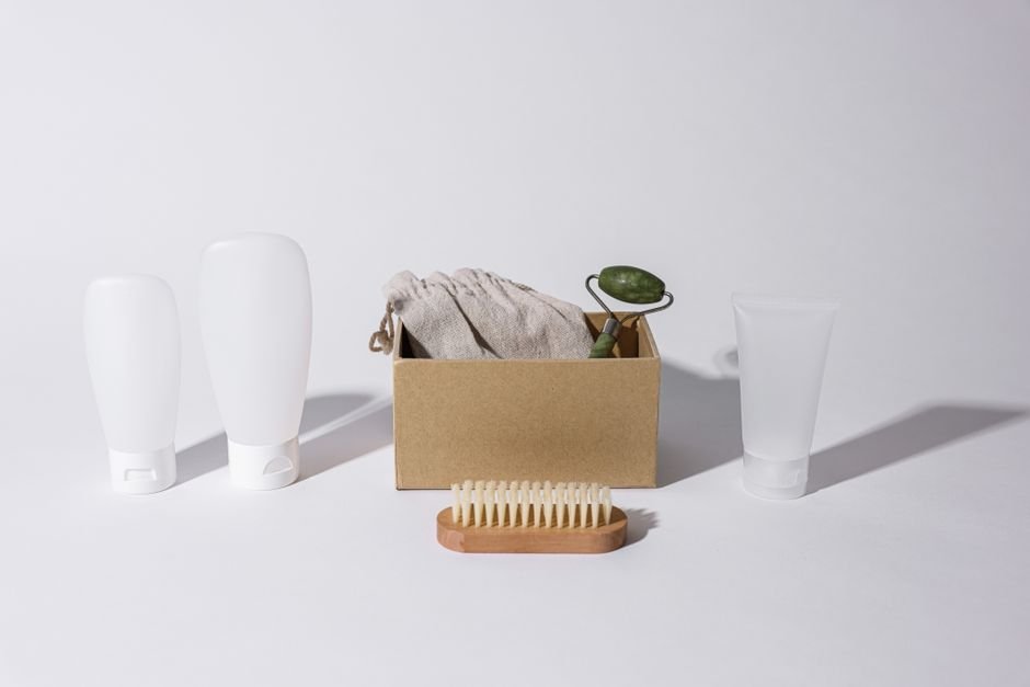 Small travel-size skincare bottles and tubes packed into a clear toiletry bag